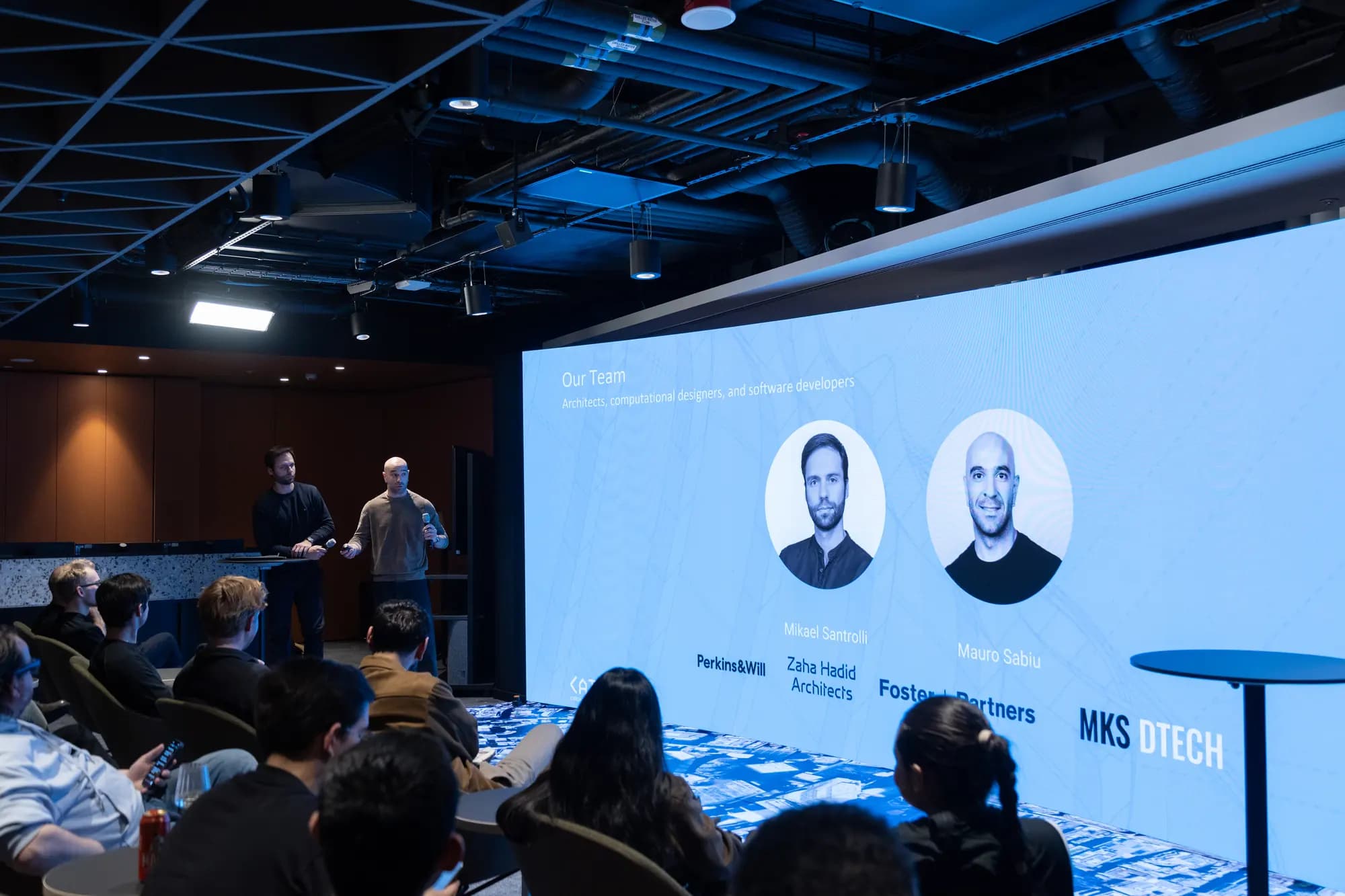 Mikael and Mauro on stage in front of a slide introducing the MKS DTECH team.
